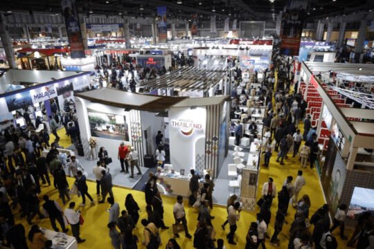 Busy exhibition hall in India showcasing Make in India initiatives with businesses, trade booths, and visitors exploring innovation in 2025