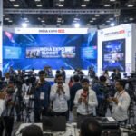 Media professionals covering a large exhibition in India with cameras, interviews, and live reporting