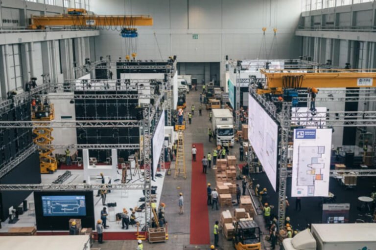 Event organisers coordinating large-scale exhibition setup with teams managing booths, logistics, and staging